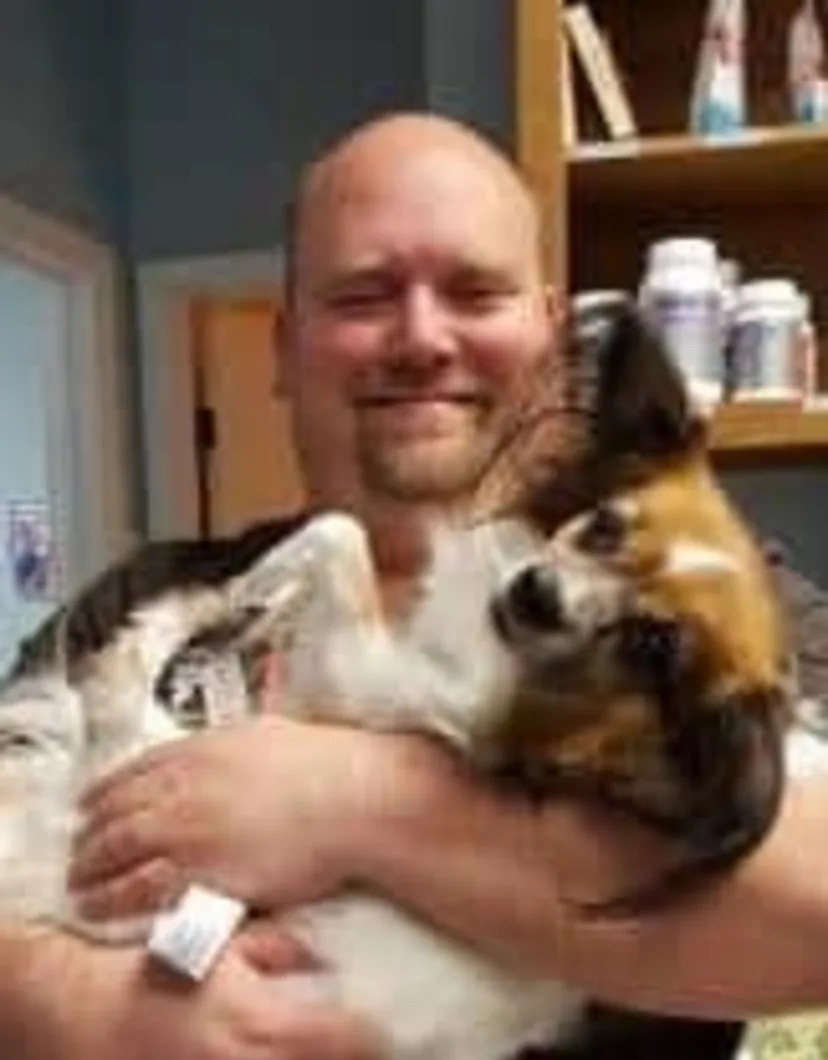 Dr. Robert Walker's staff photo from Strawbridge Animal Care where he is holding a fluffy dog.